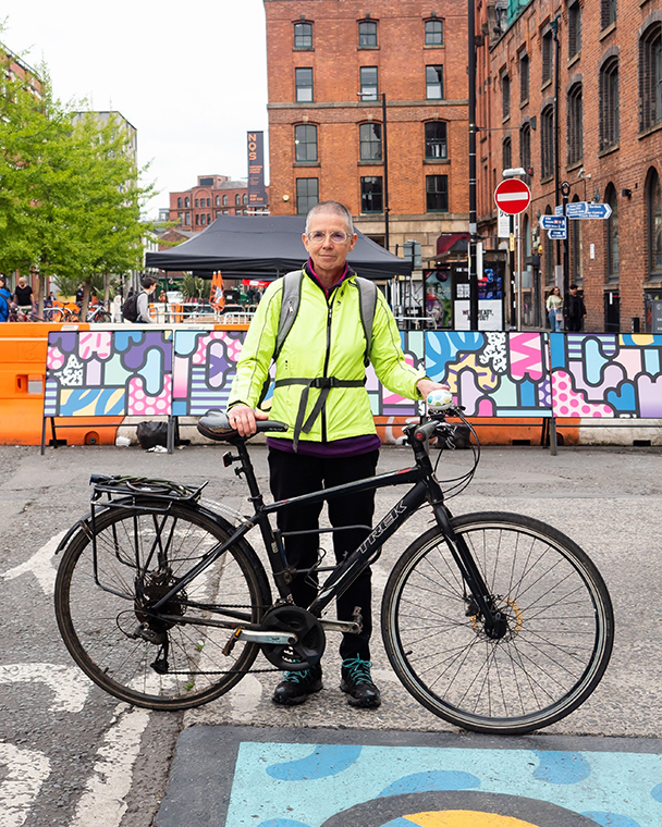 来自曼彻斯特的64岁的莉齐·金特穿着一件荧光黄色的夹克，骑着自行车站在路上。莉齐说:“老年人都过着精彩有趣的生活，他们有自己的故事，承认这一点很重要。”